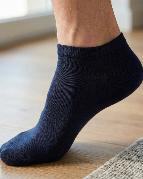 Man wearing navy bamboo ankle socks indoors, soft moisture-wicking socks for everyday wear