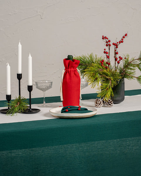 The menique linen Christmas tablecloth in dark green color.