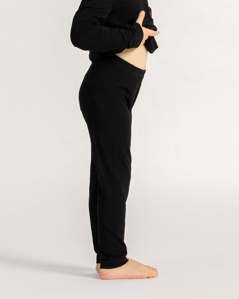 Side view of child wearing black bamboo leggings and long sleeve top, highlighting stretch and snug fit.