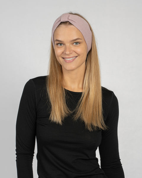 Woman wearing knitted merino wool headband, stylish ribbon design, warm winter hair accessory