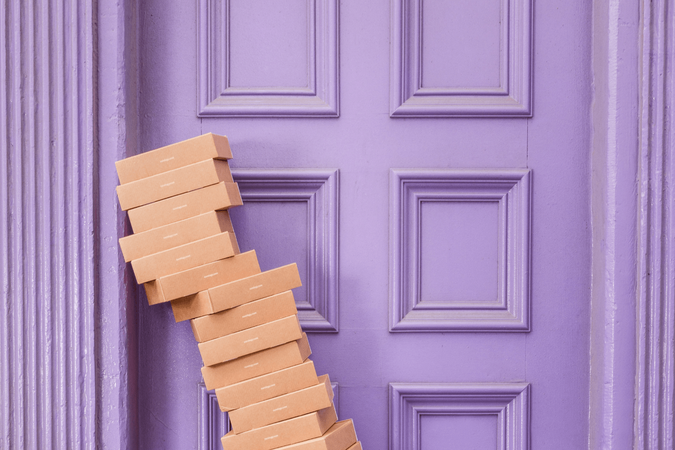 online returns are costing the earth. Picture of many card boxes piled up next to the door