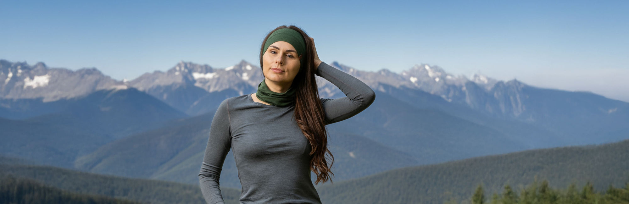Woman standing in front of mountainous landscape with clear blue sky