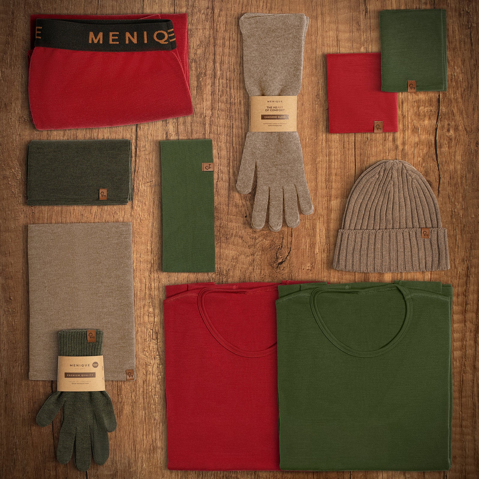 Collection of winter clothing including hats, gloves, and scarves on a wooden surface with Menlo branding.