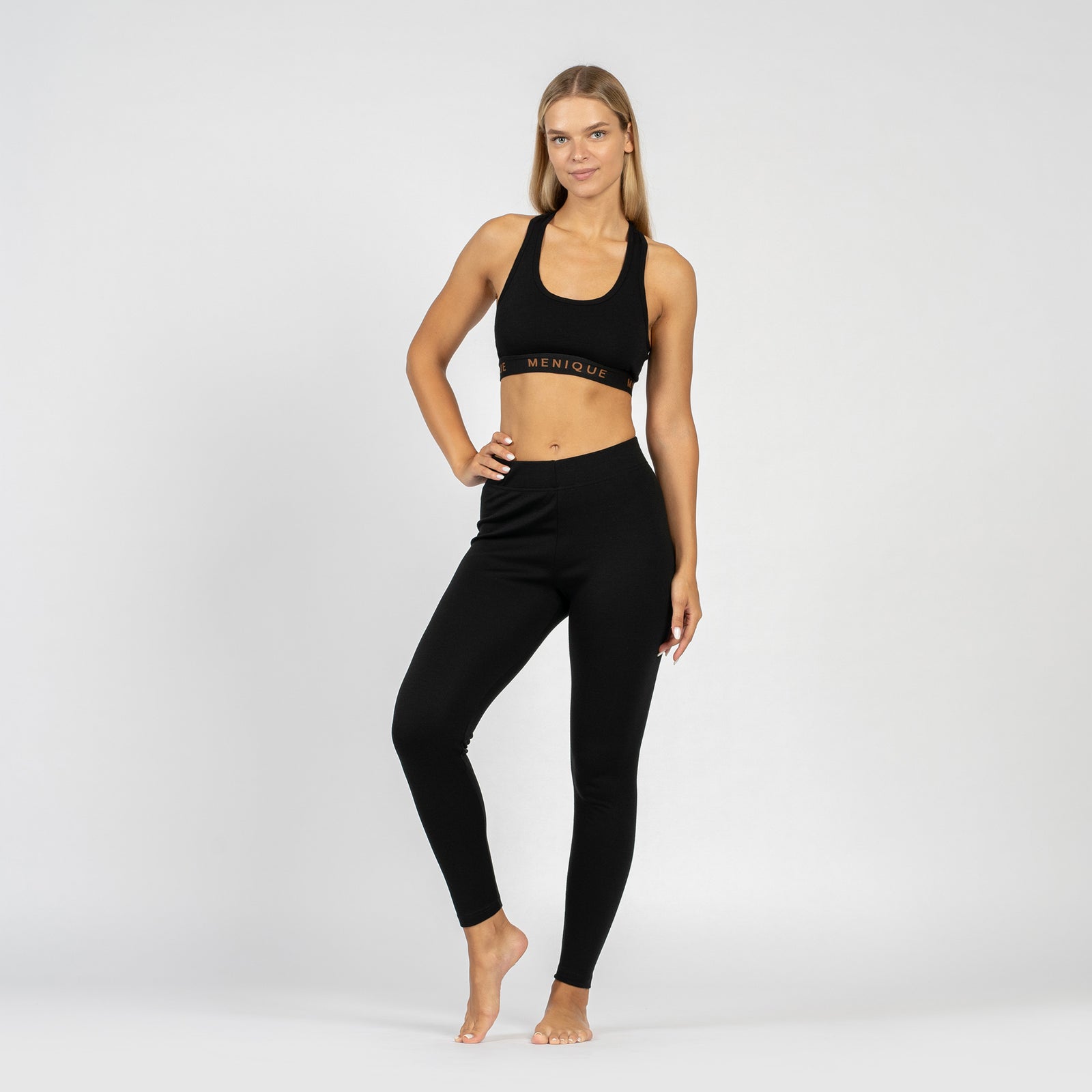 The menique women's sport bra in black color, front view, in a white background.