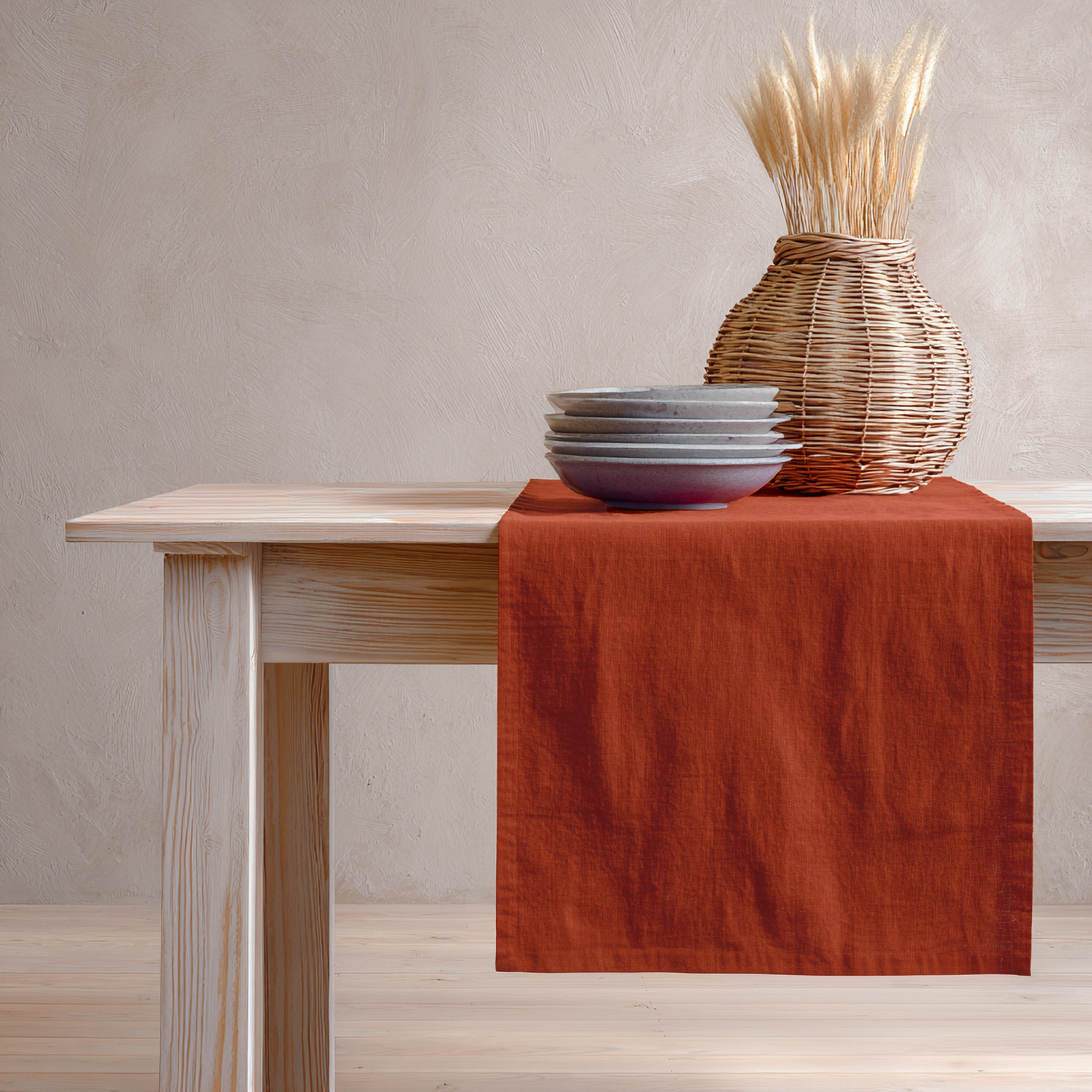 The stone green linen table runner on top of a wooden table, captured in a close up picture from the corner of the table. 
