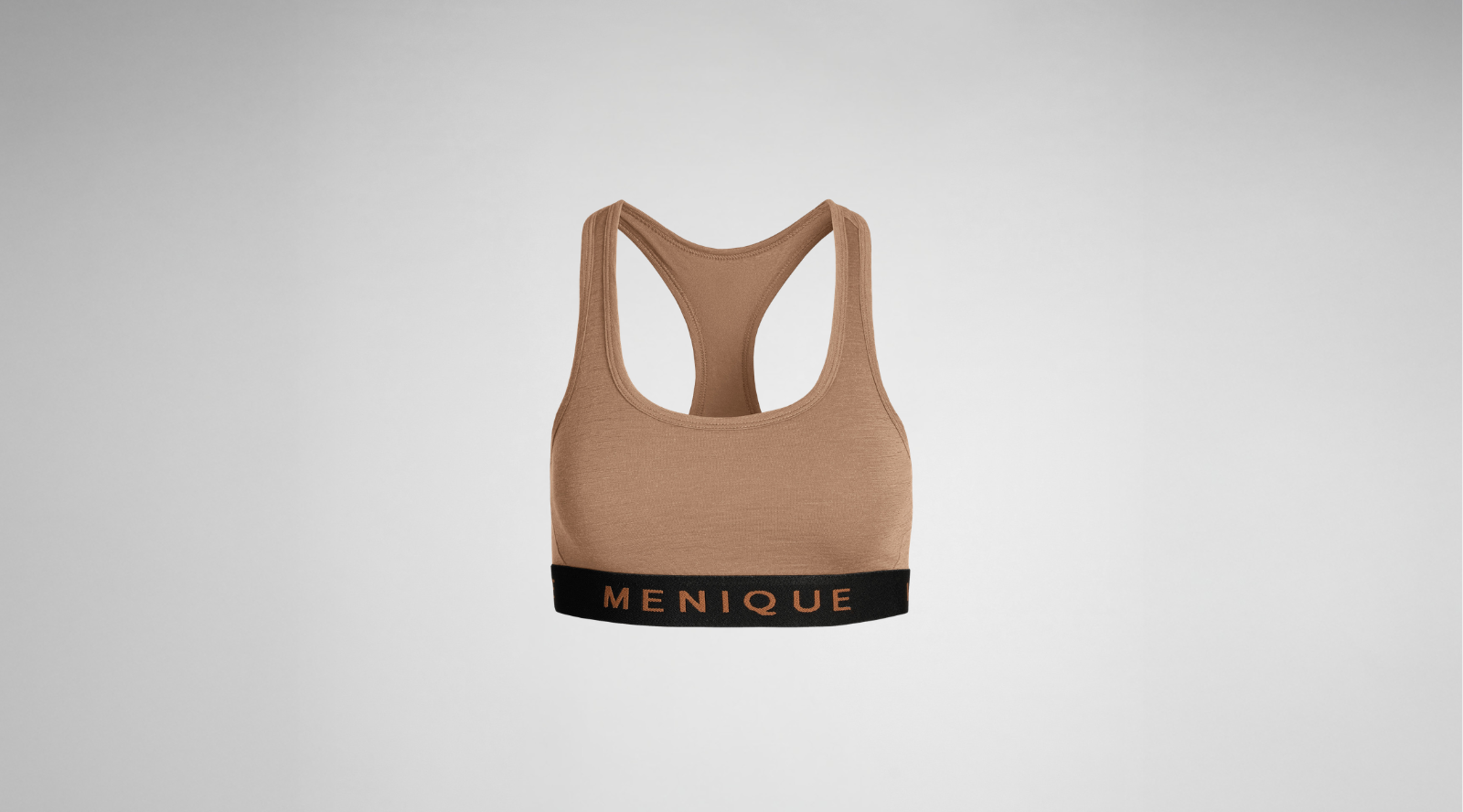 A women's taupe-colored sports bra is shown flat against a gray background. It has a racerback design and a black elastic band at the bottom featuring the word "MENIQUE" in copper letters.