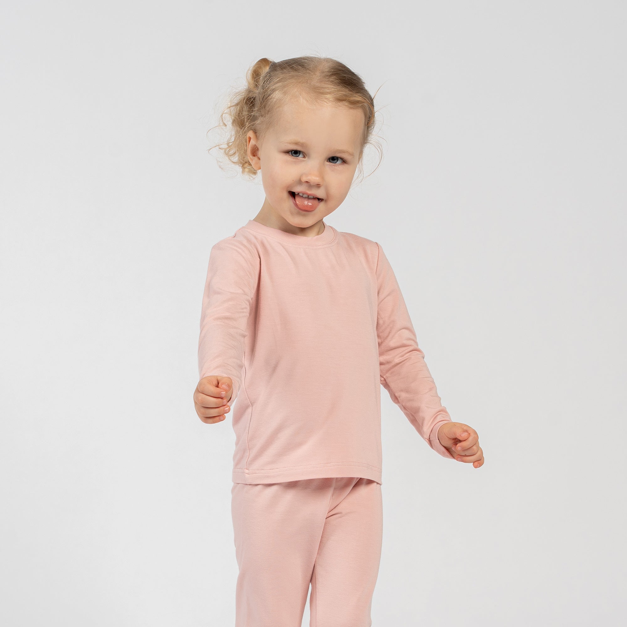 Side view of child in pink bamboo long-sleeve top and bottoms.
