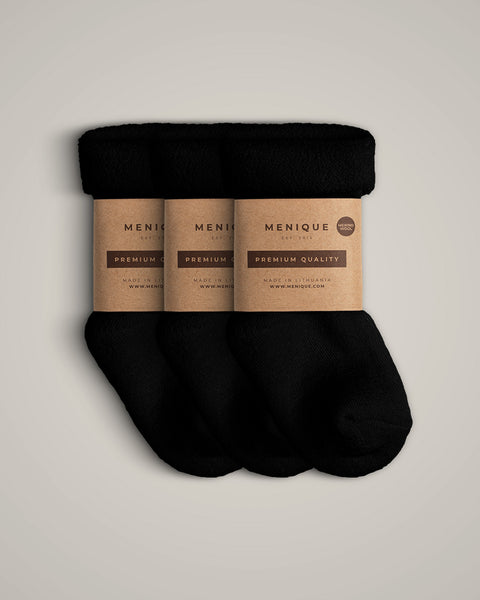 A 3-pack of kids’ black sherpa-lined merino wool socks with kraft paper Menique labels.