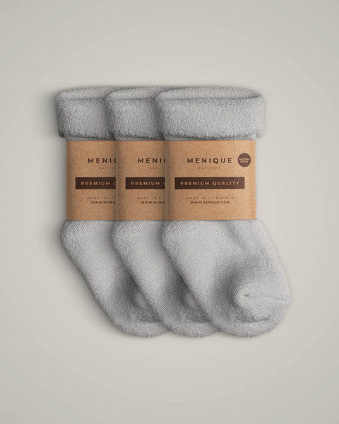 A 3-pack of kids’ light gray sherpa-lined merino wool socks with kraft paper labels.