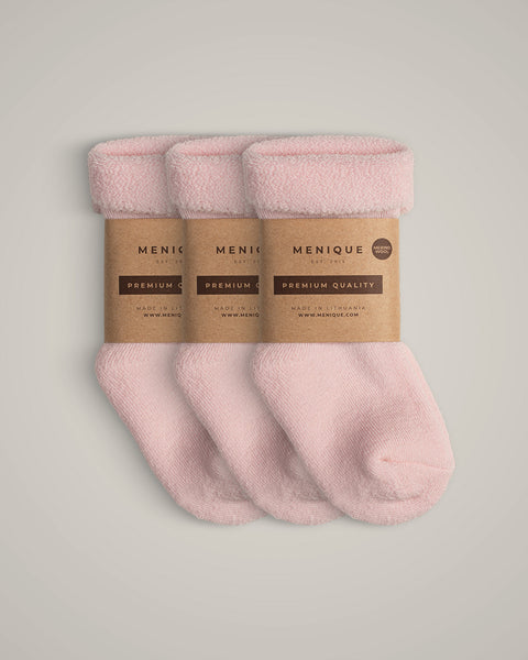 A 3-pack of kids’ light pink sherpa-lined merino wool socks, folded with brown kraft paper labels reading “Menique Premium Quality.
