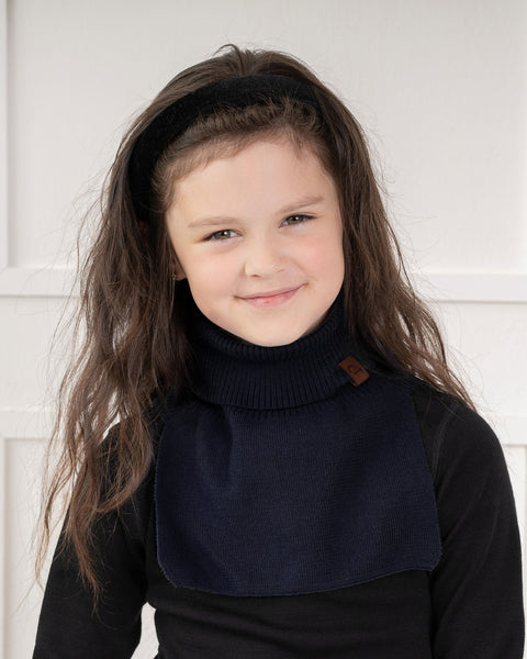 A girl wearing the cotton knit dickie in blue color, smiling, looking at the camera. 