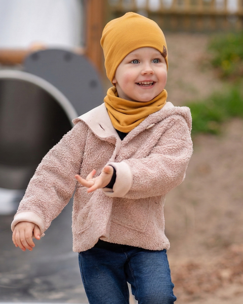 Child wearing yellow merino wool beanie and neck gaiter outdoors, warm breathable accessories for active kids.