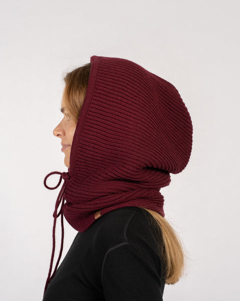 Side profile of a woman wearing a royal cherry knitted merino wool hood balaclava.