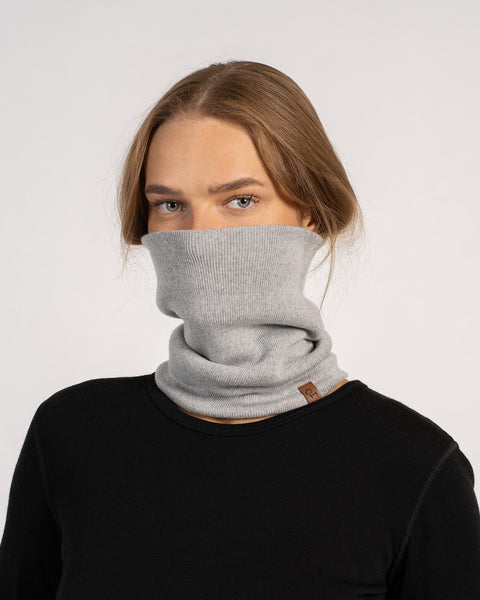 Unisex Merino Neck Gaiter in Light Gray, worn pulled up to cover the lower face, paired with a black top.