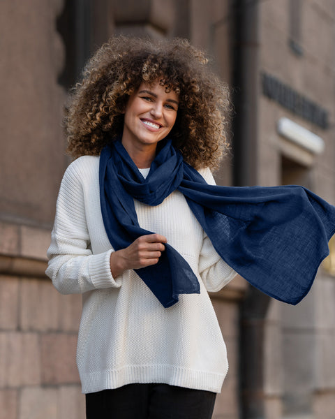 Woman wearing a storm blue linen menique scarf in front of a building