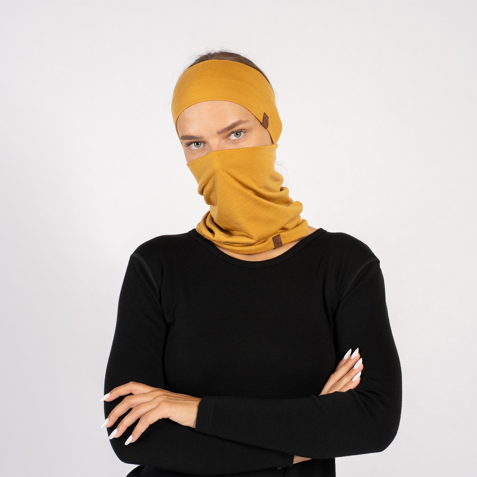 Side view of woman wearing yellow Merino wool headband and gaiter set for outdoor comfort