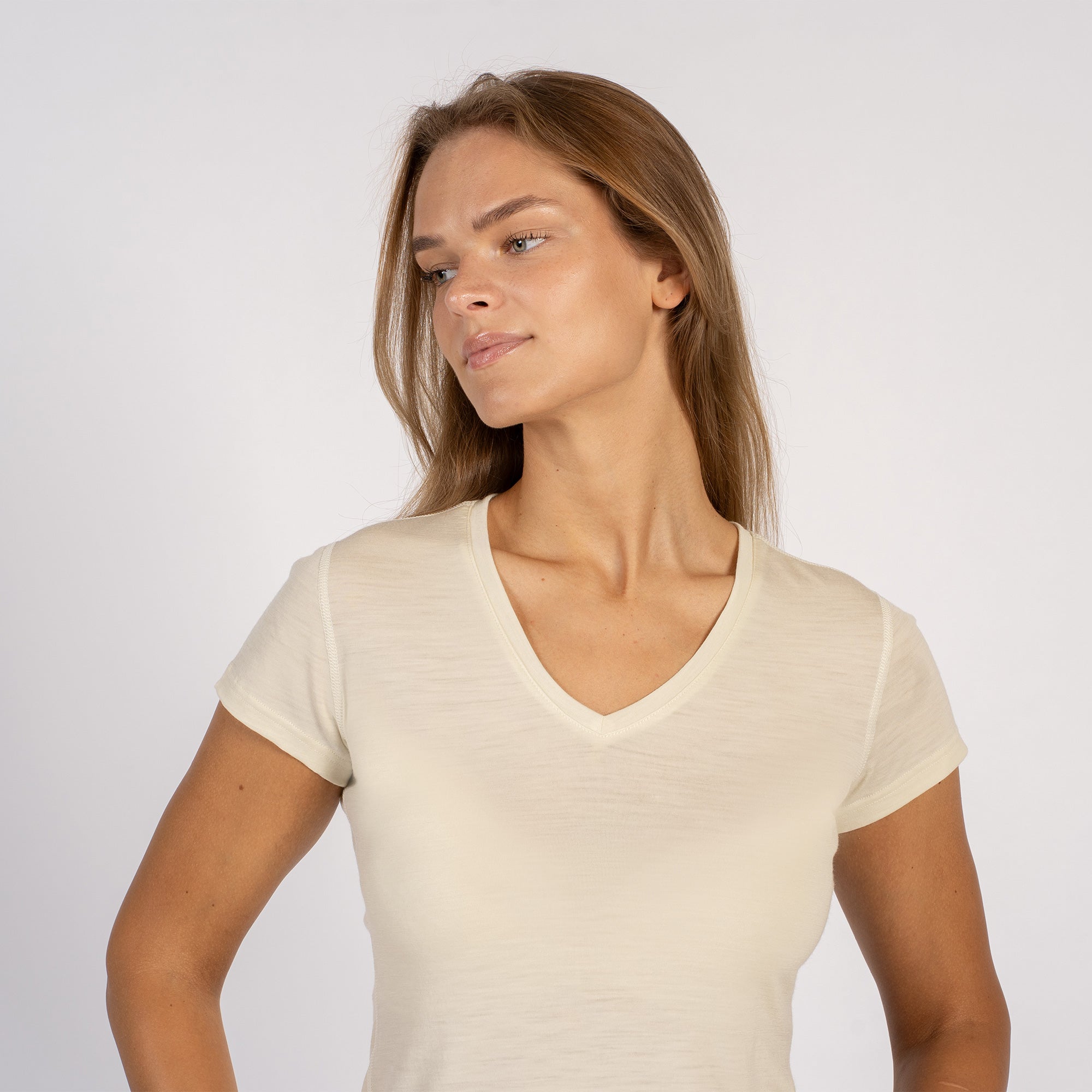 Woman wearing a natural-colored Merino wool V-neck T-shirt with short sleeves.