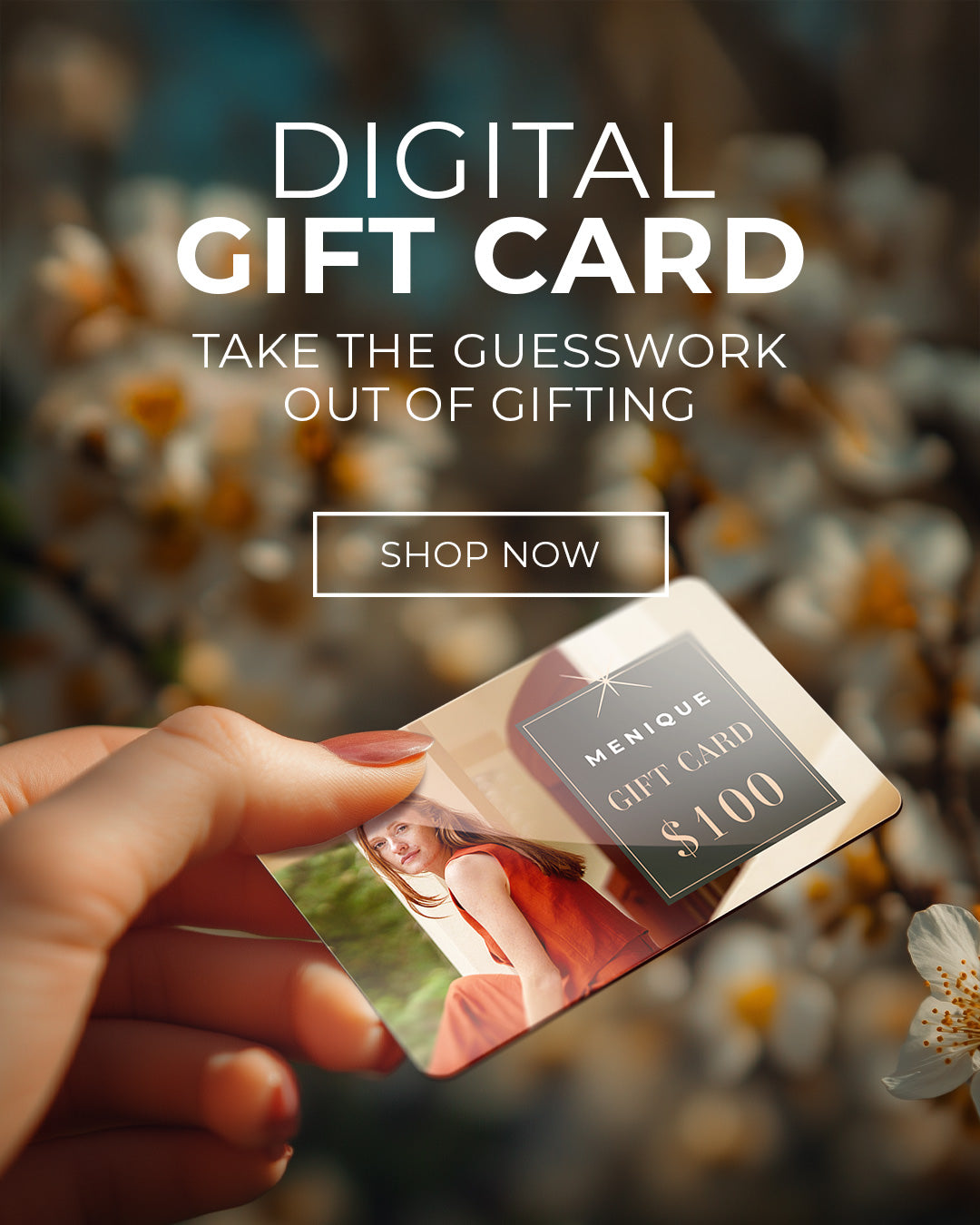 A hand holding a $100 digital gift card with a photograph on it, against a blurred floral background. The image also includes promotional text and a "SHOP NOW" button.