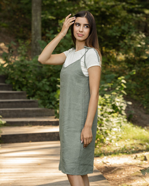 Woman standing in the forest and wearing slip dress from linen 