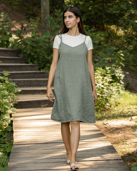 Woman walking through forest and wearing linen dress